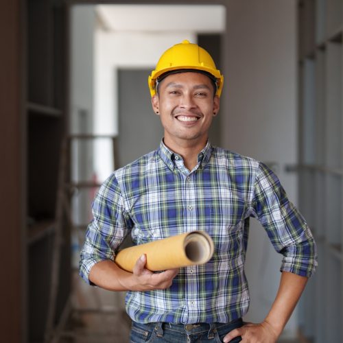 Architect man working with blueprints for architectural plan, engineer sketching a construction