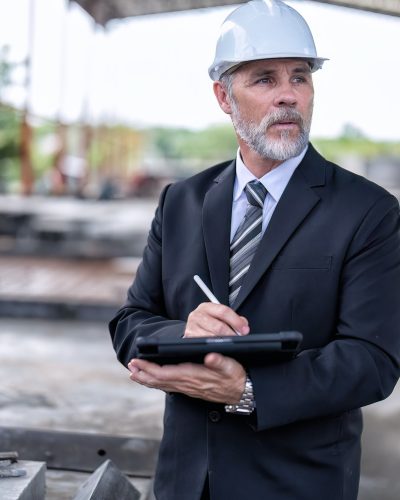 At building construction site manager check precast concrete slabs hall and record to tablet